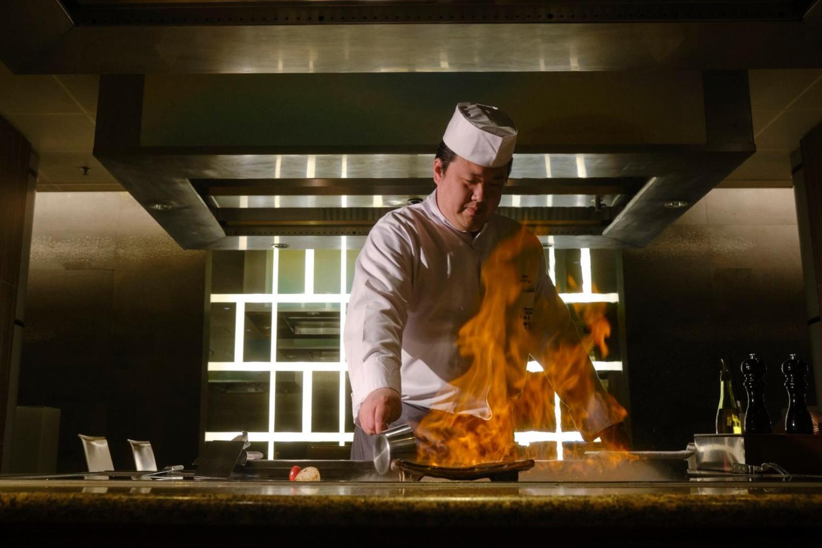 阿姆斯特丹大仓酒店 - 世界一流酒店 外观 照片 A chef cooking with a flaming wok